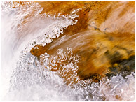 Coloured Rock, Frozen Waves: Kananaskis, AB, Canada (2010) - Fine art photo showing cascading water frozen into a sharp peaked wave in an alpine creek