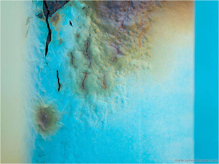 Splitting Paint, Pale Blue: Calgary, AB, Canada (2010-03-06) - Abstract macro photograph showing bubbling rusted paint between blue and amber highlights