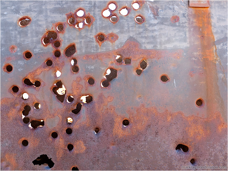 Metal Wall, Bullet Holes: Near Twentynine Palms, CA, USA (2012-01-03) - Fine art photograph of bullet holes through a rusted metal plate wall