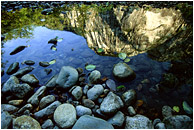 Reflection Pool, River Rocks: Squamish, BC, Canada (2002) - Abstract photograph showing reflections of cliffs and river rocks in calm water