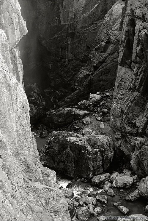 River Canyon, Mist (B&W): Near El Chorro, Spain (2006-00-00) - Fine art black and white photograph of a deep, steep-sided canyon, a misty waterfall, and a rushing river