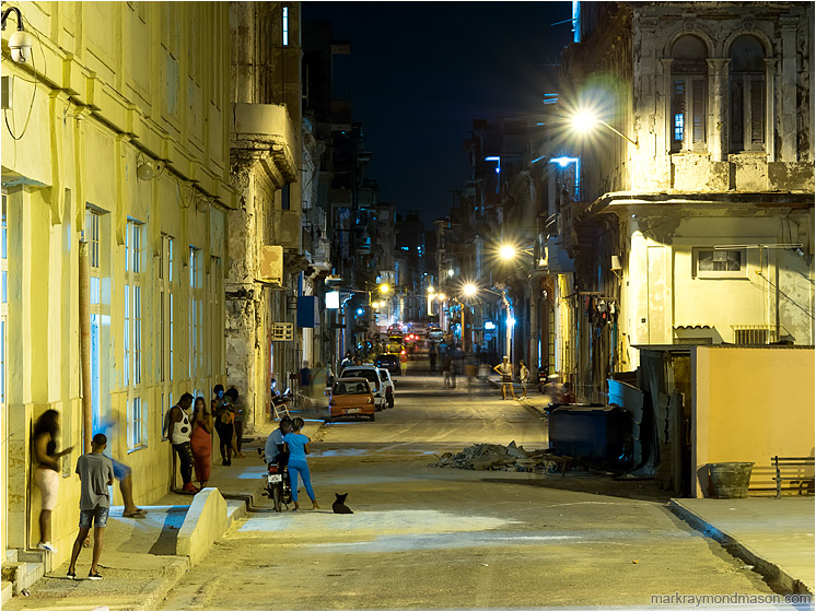 Cluttered Street, Figures, Lamplight: Havana, Cuba (2017-02-13) - Fine art photograph showing a night time street scene in downtown Havana lit by garish street lamps