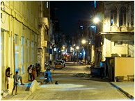 Cluttered Street, Figures, Lamplight: Havana, Cuba (2017) - Fine art photograph showing a night time street scene in downtown Havana lit by garish street lamps