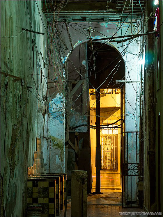 Archway, Tangled Cables: Havana, Cuba (2017-02-18) - Fine art abstract night photograph of an empty passageway between buildings, with a chaotic tangle of wires and cables overhead