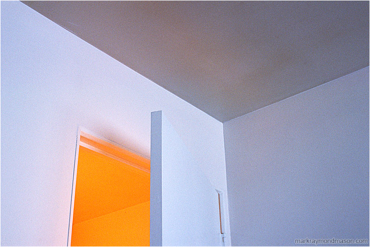 Doorway to a Yellow Room: Squamish, BC, Canada (2001-00-00) - Abstract photograph showing a partly open doorway with contrasted white, blue and yellow light