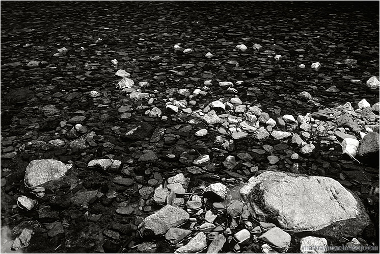 Flat Water, Rocks (B&W): Near Manning Park, BC, Canada (2005-00-00) - Fine art black and white photograph of pale and dark rocks in a flat, calm river