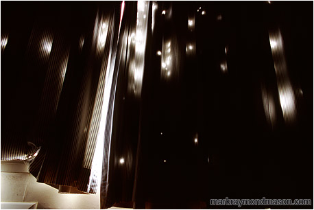 Abstract photograph of light streaming through holes in hotel curtains