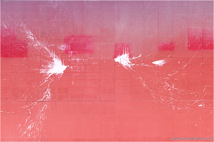 Inverted Paint Splashes: Calgary, AB, Canada (2007-00-00) - Abstract fine art photograph of arcs of white paint splashed over a dirty pink brick wall