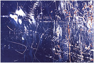 Primer, Paint, Rust: Calgary, AB, Canada (2008) - Abstract photograph of chaotic white and rusty scratches on the surface of a dark blue painted piece of scrap metal