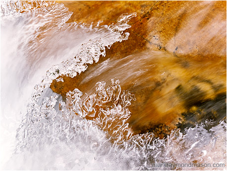 Fine art photo showing cascading water frozen into a sharp peaked wave in an alpine creek