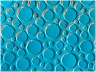 Plastic Circles, Sand: Calgary, AB, Canada (2010) - Abstract photograph showing an array of blue plastic circles, some partly filled with drifting sand