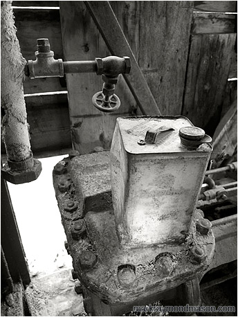 Fine art black and white photograph showing a petrol can inside the remains of an ancient excavator