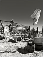 Evil Spirits (B&W): Salton Sea, CA, USA (2012) - Fine art B&W photograph showing the remains of a structure and scattered objects on a salt flat