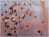 Metal Wall, Bullet Holes: Near Twentynine Palms, CA, USA (2012) - Fine art photograph of bullet holes through a rusted metal plate wall