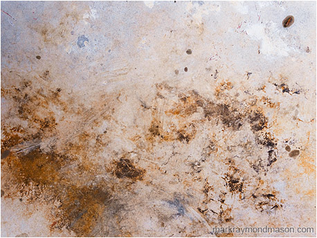 Abstract photograph showing stormy-looking stains on the surface of a plastic picnic table
