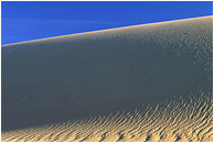 Dune, Shadows: Death Valley, CA, USA (2003) - Abstract nature photograph of shadows in a sand dune and pale blue sky