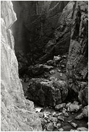 River Canyon, Mist (B&W): Near El Chorro, Spain (2006) - Fine art black and white photograph of a deep, steep-sided canyon, a misty waterfall, and a rushing river