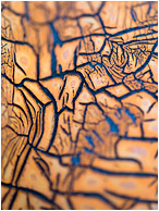 Dried Rubber, Fissures: Near Kamloops, BC, Canada (2013) - Abstract macro photograph of a network of blue cracks in an old orange cracked rubber gasket.