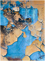 Cracking Sky, Pale Blue: Near Kamloops, BC, Canada (2013) - Abstract macro photograph showing large chunks of peeling orange paint falling away to reveal cool, blue-tinted metal beneath