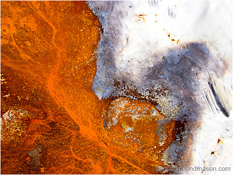 Fine art abstract photo showing rusted metal and chipped paint curving together like a shoreline on a lake