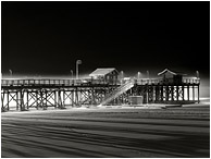 Wharf, Lamplight, Winter Fog: Salmon Arm, BC, Canada (2016) - Fine art black and white photograph showing a thin shroud of fog around a lone snow-lined wharf on a black winter night
