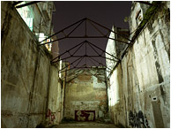 Graffiti, Steel Trusses, Night Sky: Havana, Cuba (2017) - Fine art photograph showing a vacant urban canyon between concrete buildings, with exposed trusses against a starry sky