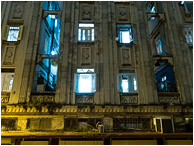 Towering Building, Lighted Windows: Havana, Cuba (2017) - Fine art photograph showing windows open to the night and spilling blue light into the arc-sodium lit streets