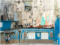 Standing Couple, Broken Walls, Graffiti: Havana, Cuba (2017) - Fine art travel photograph showing a young Cuban couple talking in front of the ruins of a large concrete building