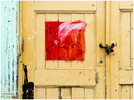 Yellow Door, Red Panel, Lock: Havana, Cuba (2017) - Fine art abstract photograph showing a red painted square, like a framed picture, in the middle of an ageing wooden door