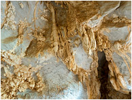 Cave Ceiling, Graffiti: Near Vinales, Cuba (2017) - Abstract photo showing popcorn rock and stalactites on the roof of a cave, with black charcoal graffiti all around