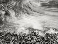 Rocks, Clouded Sea: Olympic National Park, WA, USA (2017) - Fine art black and white long-exposure photograph showing moving water swirling like fog around seaside stones